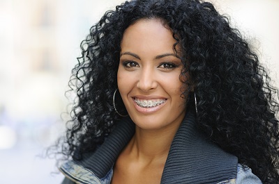 Black woman with curly hair and braces smiling 