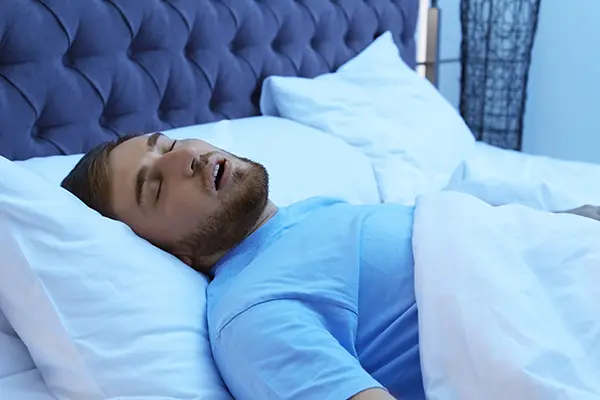 White man with sleep apnea snoring while trying to sleep in bed