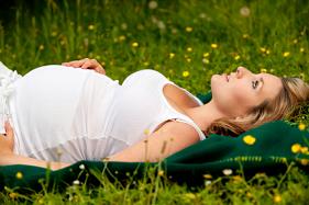 Pregnant woman laying in glass